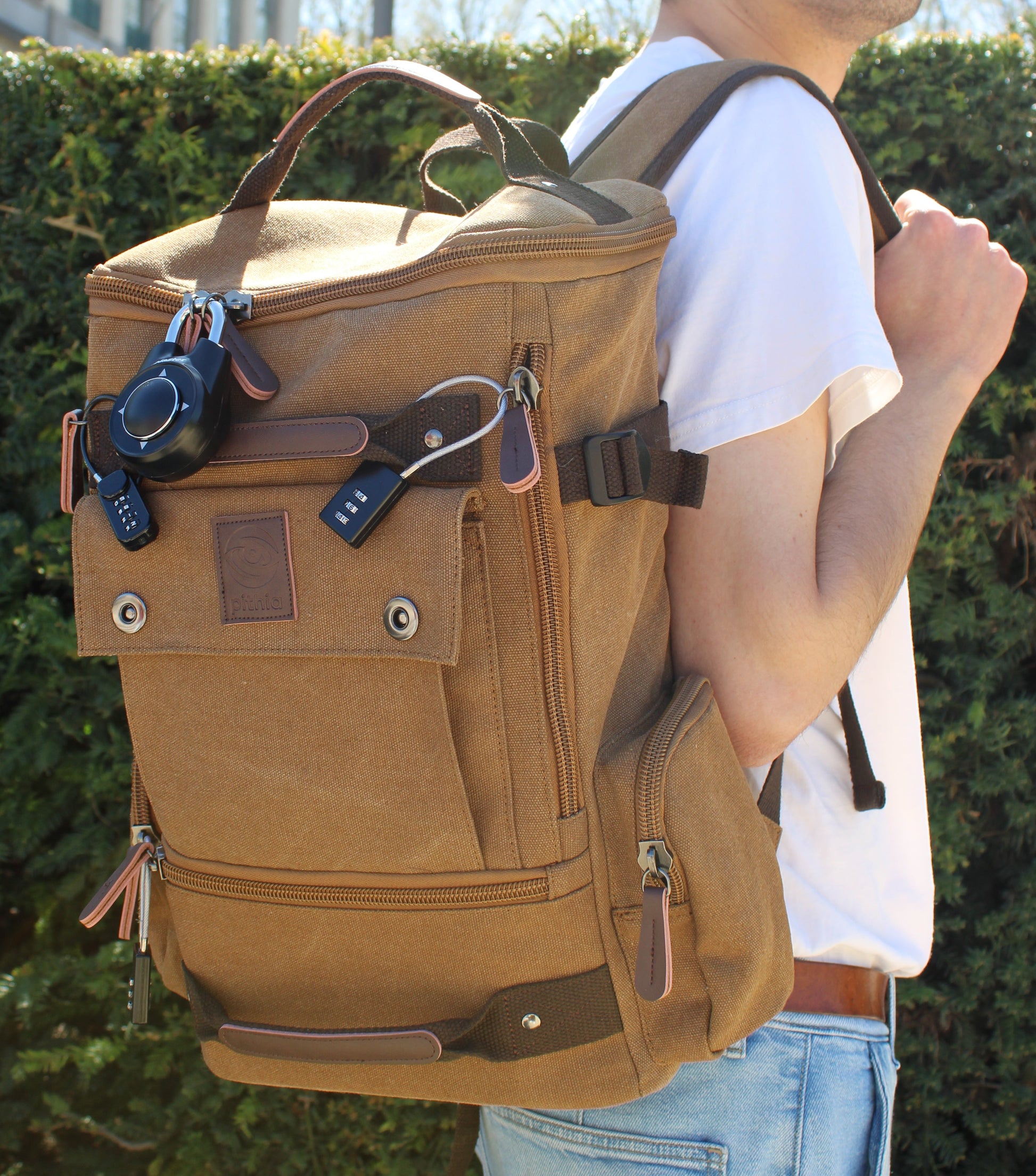 Person wearing a tan backpack with keys attached outdoors